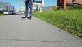 Disabled person walking on a pedestrian road in a big city. There`s a road in the background. Limping and tiptoeing