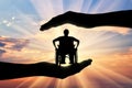 Disabled person in wheelchair in hands on sunset