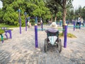 Disabled person in a wheelchair working out on public equipment