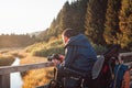 Disabled photographer taking a photo of mountain nature at dusk Royalty Free Stock Photo