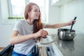 Disabled redhaired ginger woman in wheelchair preparing meal in kitchen Royalty Free Stock Photo