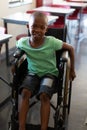 Disabled schoolboy looking at camera in a classroom