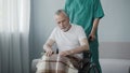 Disabled senior man sitting in wheelchair, male nurse supporting patient Royalty Free Stock Photo
