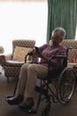 Disabled senior woman using mobile phone in living room Royalty Free Stock Photo