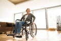 Disabled senior woman in wheelchair at home in living room. Royalty Free Stock Photo