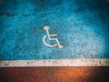 Disabled parking invalide sign painted on the blue asphalt Royalty Free Stock Photo