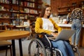 Disabled student in wheelchair works on laptop