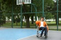 Disabled teenage boy in wheelchair with ball at outdoor court Royalty Free Stock Photo