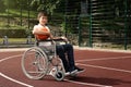 Disabled teenage boy in wheelchair with basketball ball at court Royalty Free Stock Photo