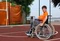 Disabled teenage boy in wheelchair with ball at outdoor court Royalty Free Stock Photo