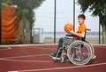 Disabled teenage boy in with basketball ball at outdoor court Royalty Free Stock Photo