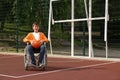Disabled teenage boy in wheelchair with ball at outdoor court Royalty Free Stock Photo