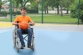Disabled teenage boy in wheelchair with basketball ball at court Royalty Free Stock Photo