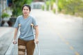 Disabled woman with crutches or walking stick or knee support standing in back side,half body
