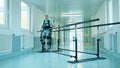 Disabled woman is doing physiotherapy in the exosuit