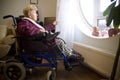 Disabled woman looks out the window Royalty Free Stock Photo