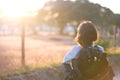 A disabled woman standing outside looking at the sunset reflecting