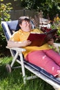 Disabled woman reading a book in the garden Royalty Free Stock Photo