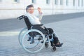 Disabled woman sitting outside and waving Royalty Free Stock Photo