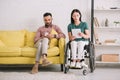 Disabled woman using digital tablet near handsome boyfriend sitting on sofa with smartphone Royalty Free Stock Photo