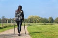 Disabled woman walking on crutches in nature