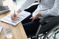 Disabled woman in wheelchair filling out application for employment closeup Royalty Free Stock Photo