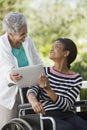 Disabled woman in a wheelchair with her mother Royalty Free Stock Photo