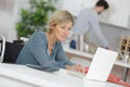 Disabled woman in wheelchair on laptop with purple background