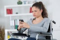 Disabled woman in wheelchair on mobile phone Royalty Free Stock Photo