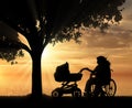 Disabled woman in wheelchair and pram under tree