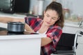 Disabled woman in wheelchair preparing meal in kitchen Royalty Free Stock Photo