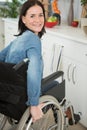 disabled woman in wheelchair preparing meal in kitchen