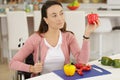 Disabled woman in wheelchair preparing meal in kitchen Royalty Free Stock Photo