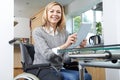 Disabled Woman In Wheelchair Using Digital Tablet At Home Royalty Free Stock Photo