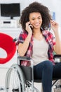 disabled woman in wheelchair using mobile phone at home Royalty Free Stock Photo