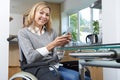 Portrait Of Disabled Woman In Wheelchair Using Mobile Phone At H Royalty Free Stock Photo