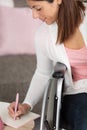 disabled woman in wheelchair writes notes Royalty Free Stock Photo