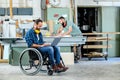 Worker in wheelchair in a carpenters workshop with his colleagu Royalty Free Stock Photo