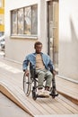 Young man in wheelchair moving down ramp Royalty Free Stock Photo