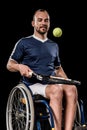 Disabled young sportsman sitting in wheelchair and playing tennis