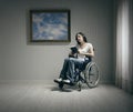 Disabled young woman reading in a wheelchair