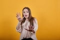 Disapointed woman in fashion pastel shirt showing palms aside, stop, NO gesture