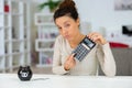 disappointed beautiful young female entrepreneur with calculator