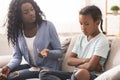 Disappointed black mother looking at her little daughter with reproach
