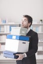 Disappointed businessman carrying boxes