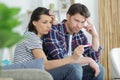 Disappointed couple looking regretfully at pregnancy test