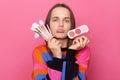 Disappointed displeased woman wearing sweater holding cosmetic brush powder looking with pout lips being in bad mood posing Royalty Free Stock Photo