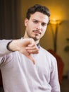 Disappointed or displeased young man doing thumb down sign Royalty Free Stock Photo