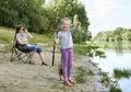 Disappointed girl child look on caught fish, grimacing face, people camping and fishing, family active in nature, river and forest Royalty Free Stock Photo