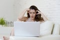 Disappointed girl at home couch using internet for studying with laptop computer Royalty Free Stock Photo